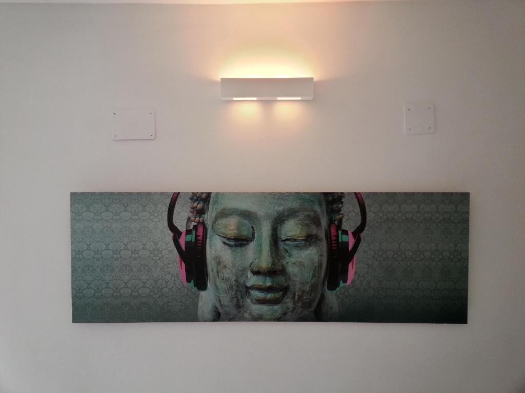 a picture of a woman wearing headphones on a wall at Apartment Tara in Sumartin