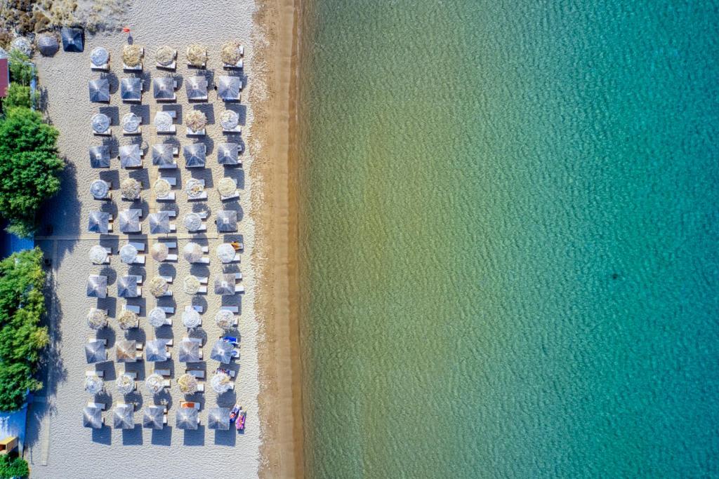 an overhead view of a bunch of chairs and the water at Platy Beach Hotel in Platy