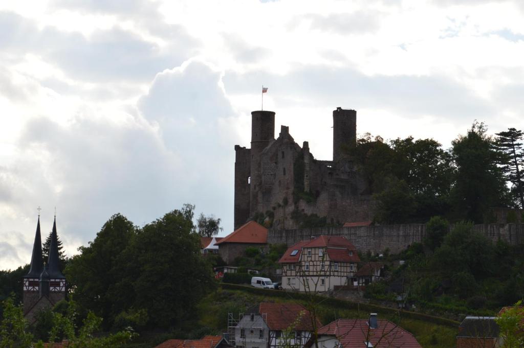 um castelo no topo de uma colina com casas em Apartment unterhalb der Burg Hanstein em Bornhagen
