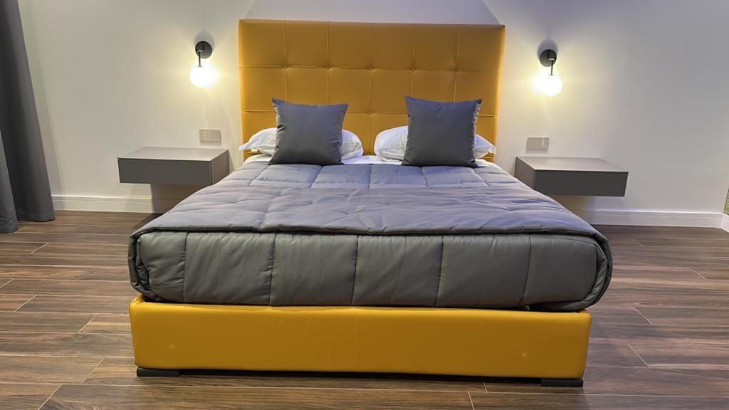 a yellow bed in a room with two tables at palazzo chinial in Torre del Greco