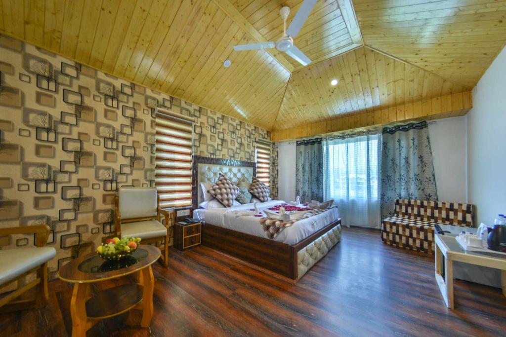 ein Schlafzimmer mit einem großen Bett und ein Wohnzimmer in der Unterkunft hotel pearl continental in Srinagar