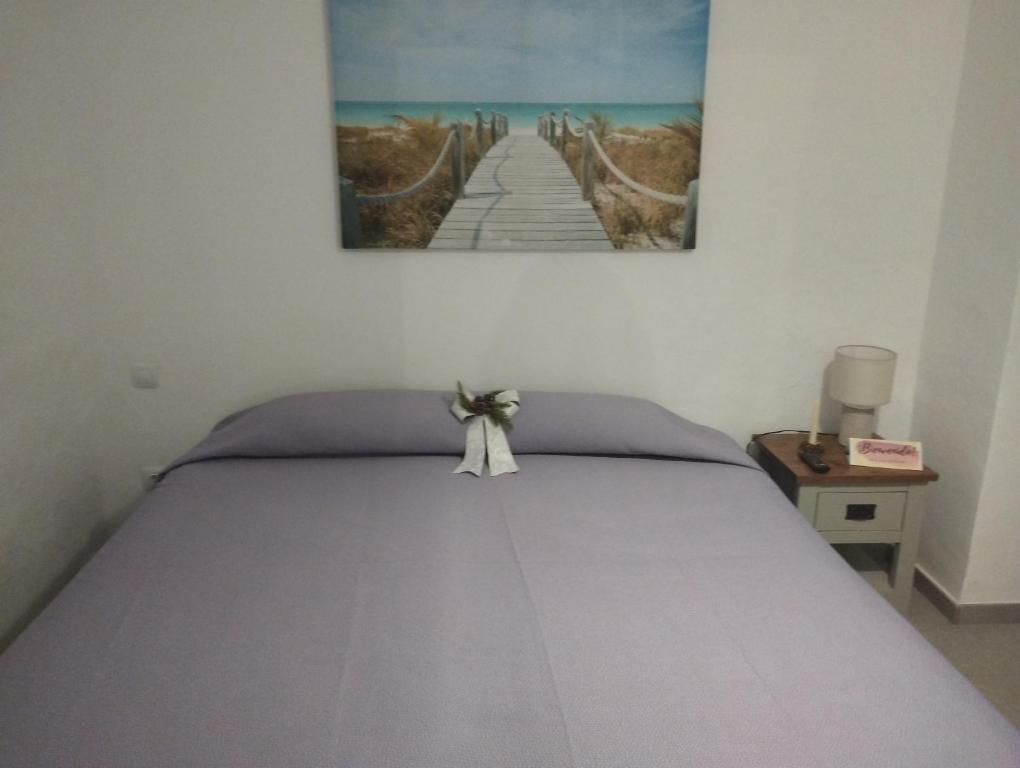 1 dormitorio con 1 cama con una pintura en la pared en Casa las Águilas, Lajares en Lajares