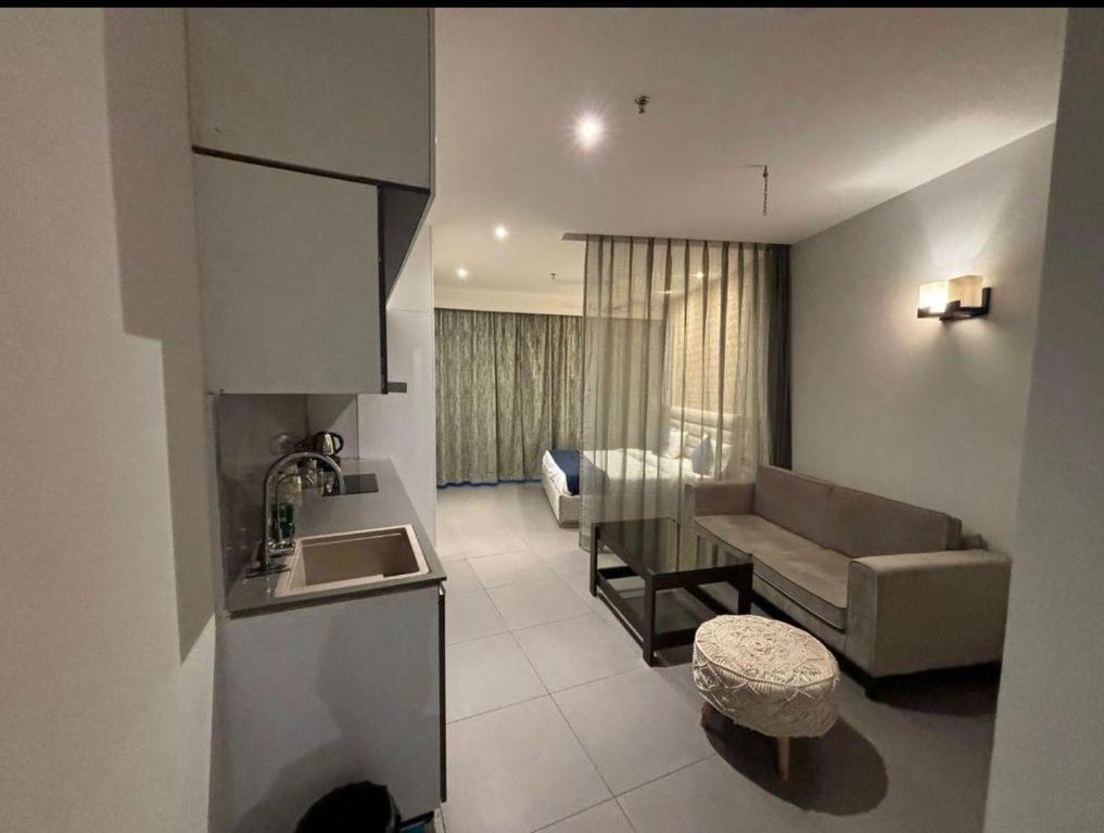 a kitchen and living room with a couch and a table at Skystay in Greater Noida