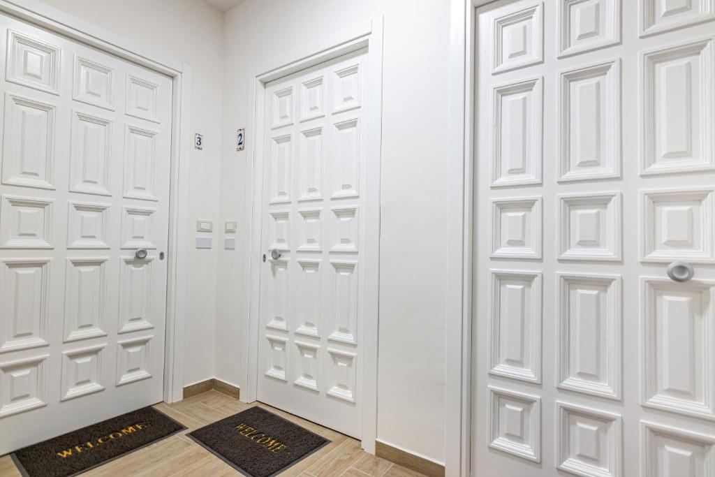 un vestidor con puertas blancas y una alfombra en Agio Apartments Diamante - Bilocale, en Diamante