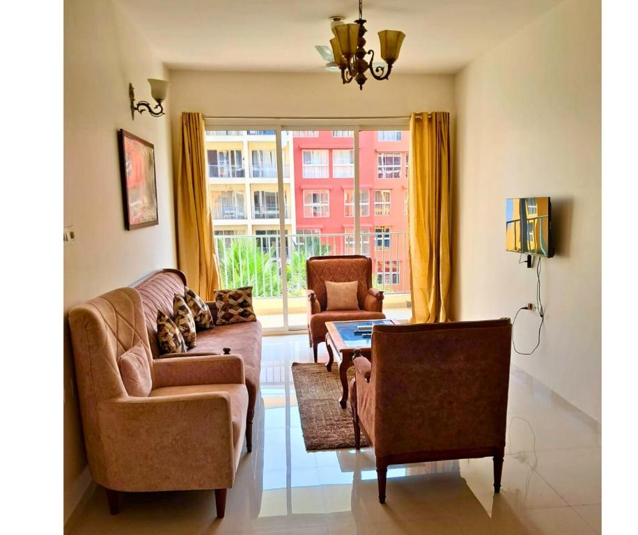 un salon avec un canapé et deux chaises dans l'établissement Pool view 2BHK 10 min to GOI airport & beach, à Dabolim