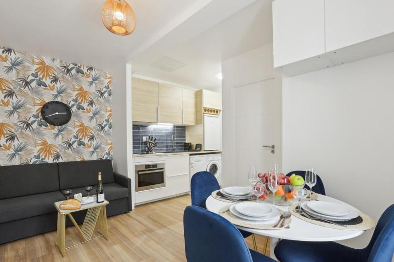 862 Suite Tulipe - Superb apartment في مونتروي: مطبخ وغرفة طعام مع طاولة وكراسي زرقاء