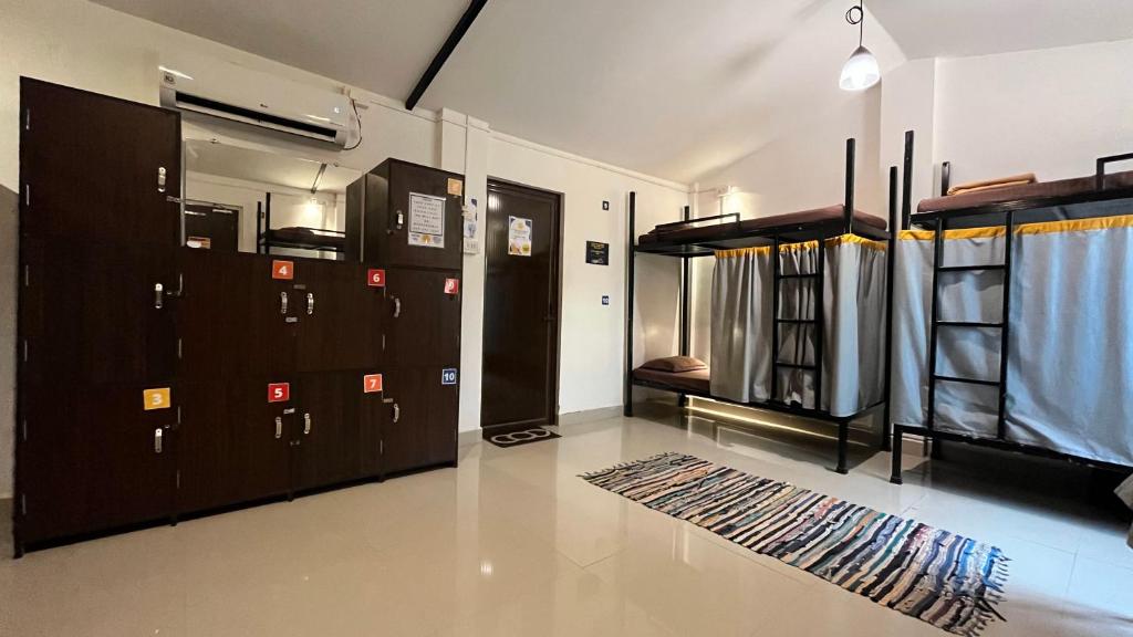 a room with several bunk beds and a rug at BunkNBrew in Palolem