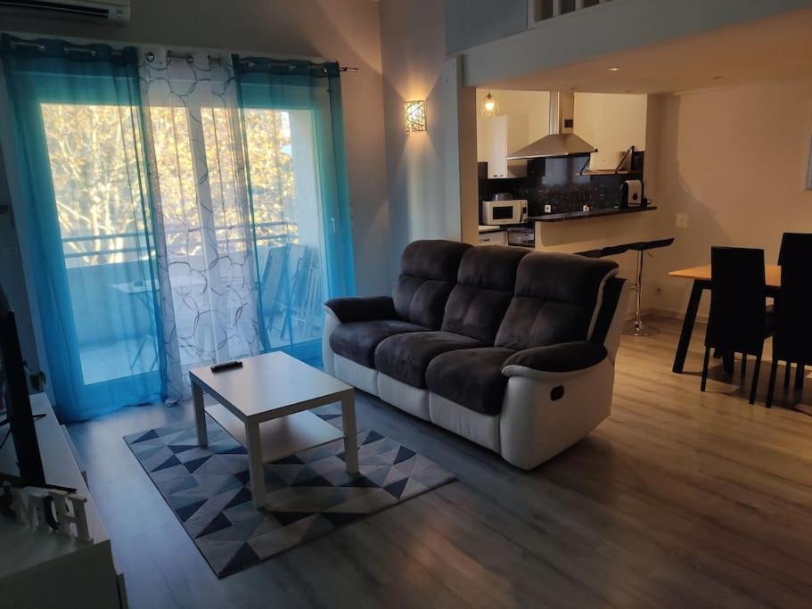un salon avec un canapé et une table dans l'établissement Joli appartement dans quartier calme de Perpignan, à Perpignan