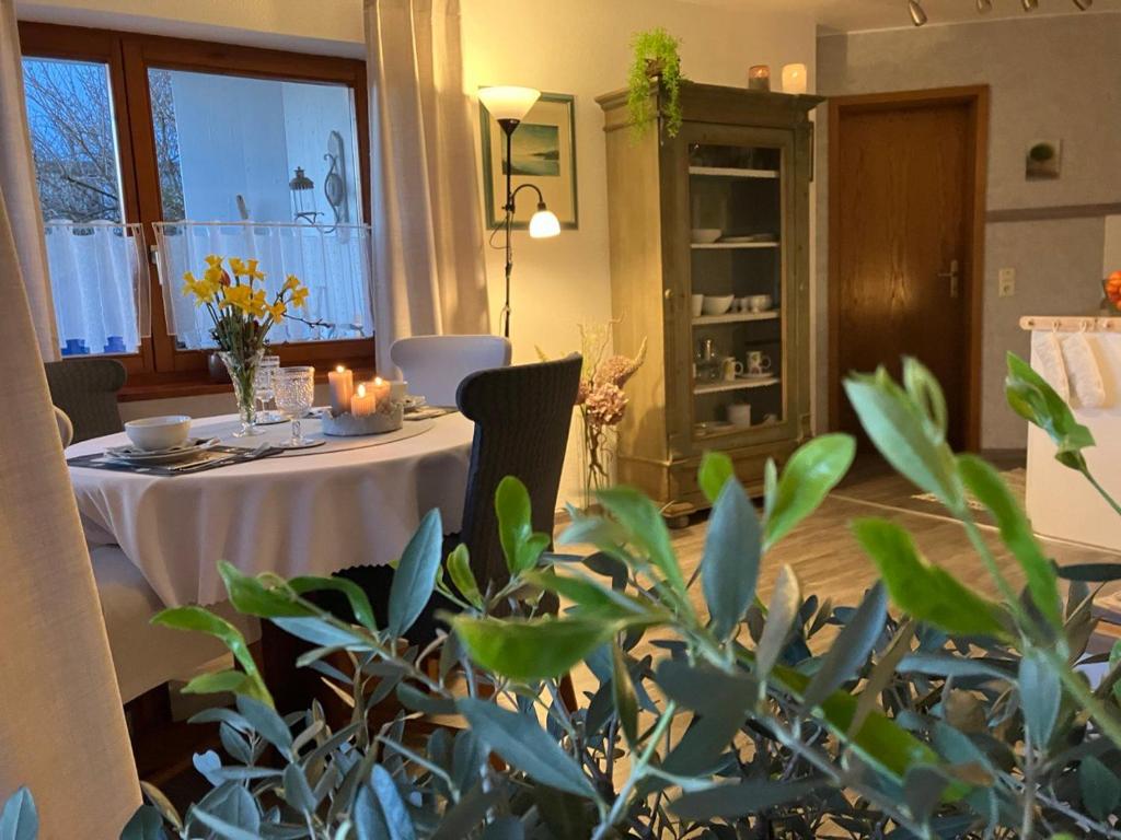 ein Esszimmer mit einem Tisch und einem weißen Tischtuch in der Unterkunft Ferienwohnung Angelika in Kressbronn am Bodensee