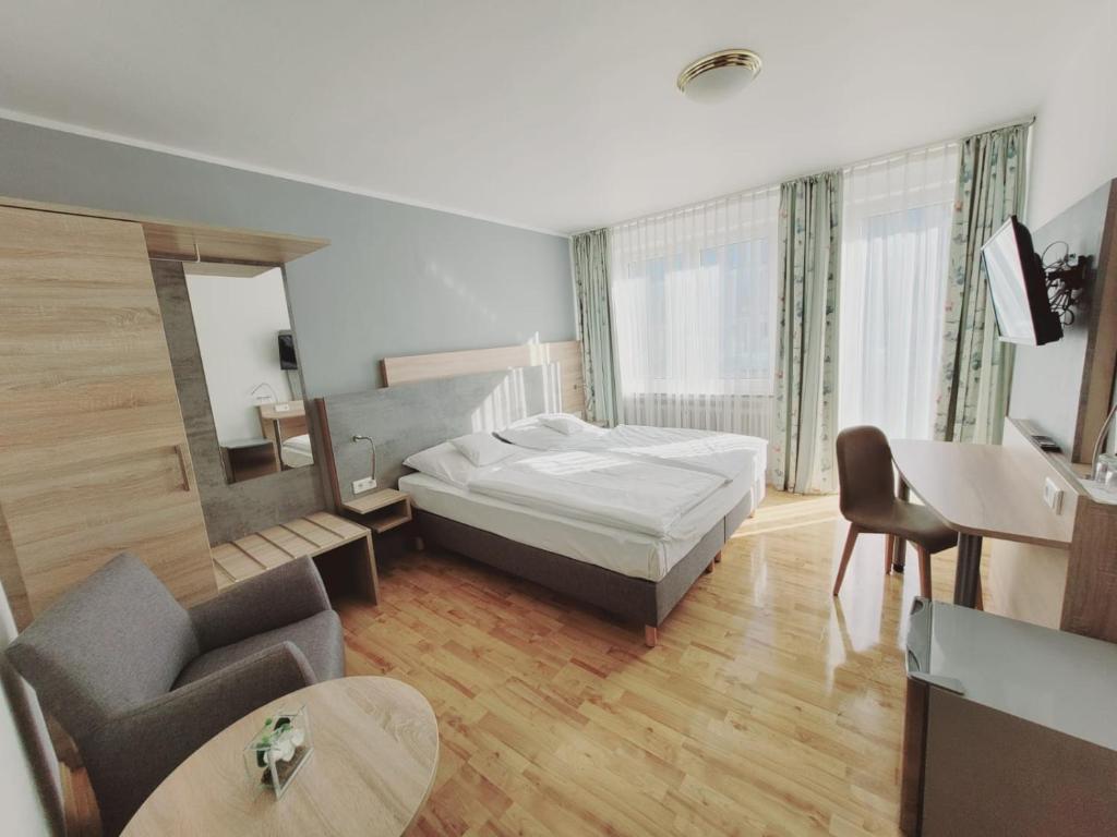 a bedroom with a bed and a couch and a table at Hotel Europa in Bonn