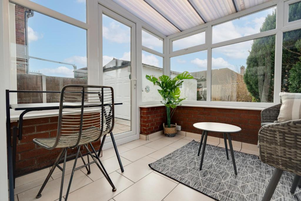 een afgeschermde veranda met 2 stoelen en een tafel bij Leyland House - Private Parking Free Wi-Fi Garden in Leyland