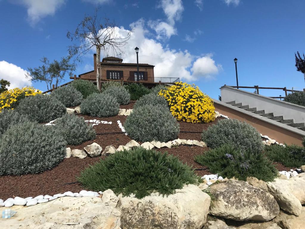 a garden with bushes and rocks in front of a house at Love Nests by The Bell Tower Lodge in Palidoro