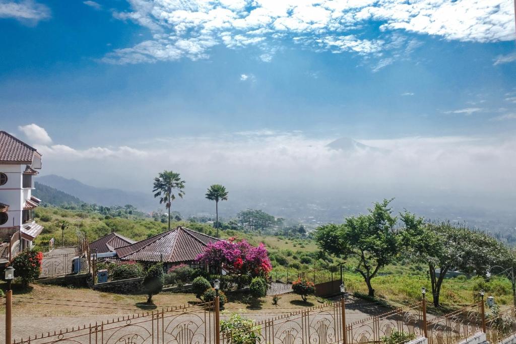 a view of a house with a fence and trees at OYO 1194 Villa Bukit Panderman Residence in Tlekung