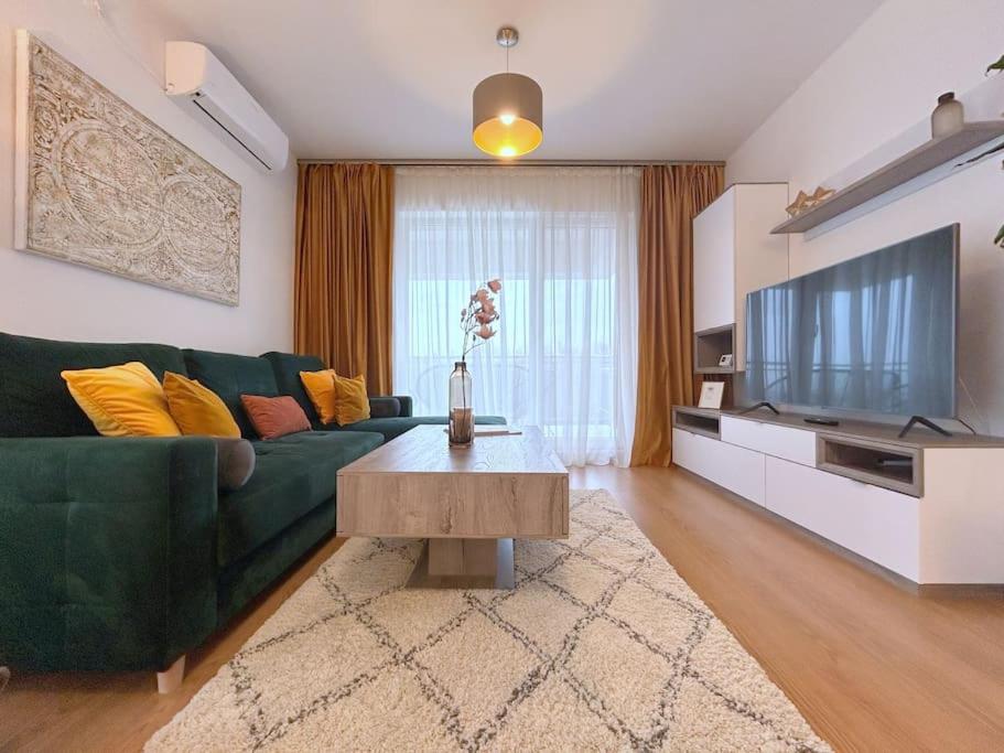 a living room with a green couch and a television at ForestHouse 2 in Timişoara