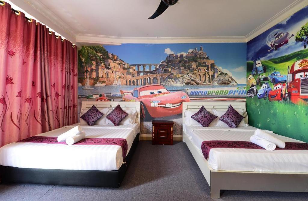 two beds in a room with a mural at Seeds Hotel Shah Alam Section 7 in Shah Alam