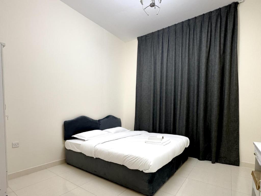 ドバイにあるLehbab Star Residence - Home Stayの黒いカーテン付きの部屋のベッド1台