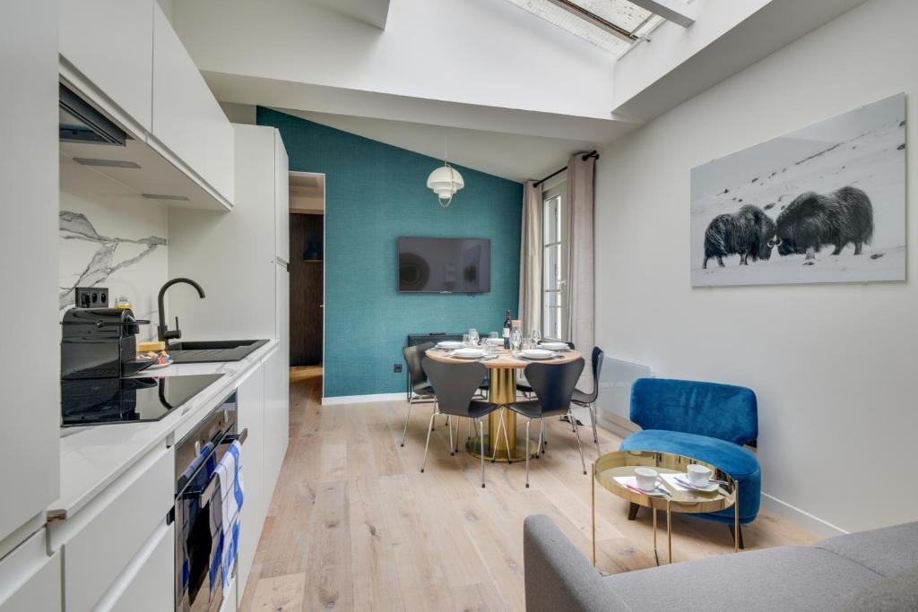 a kitchen and dining room with a table and chairs at 141 Suite Klein - Superbe Appartement à Paris. in Paris