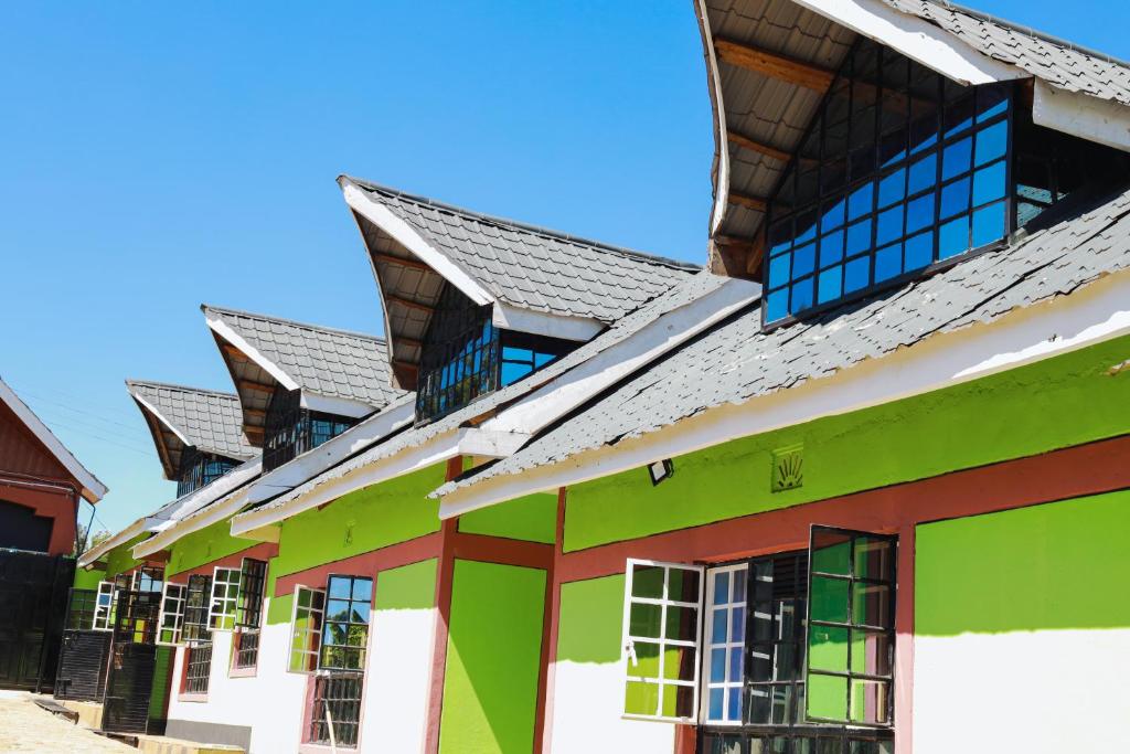 a row of green and white buildings with windows at Gerly Homes Hotel & Restaurant in Kakamega