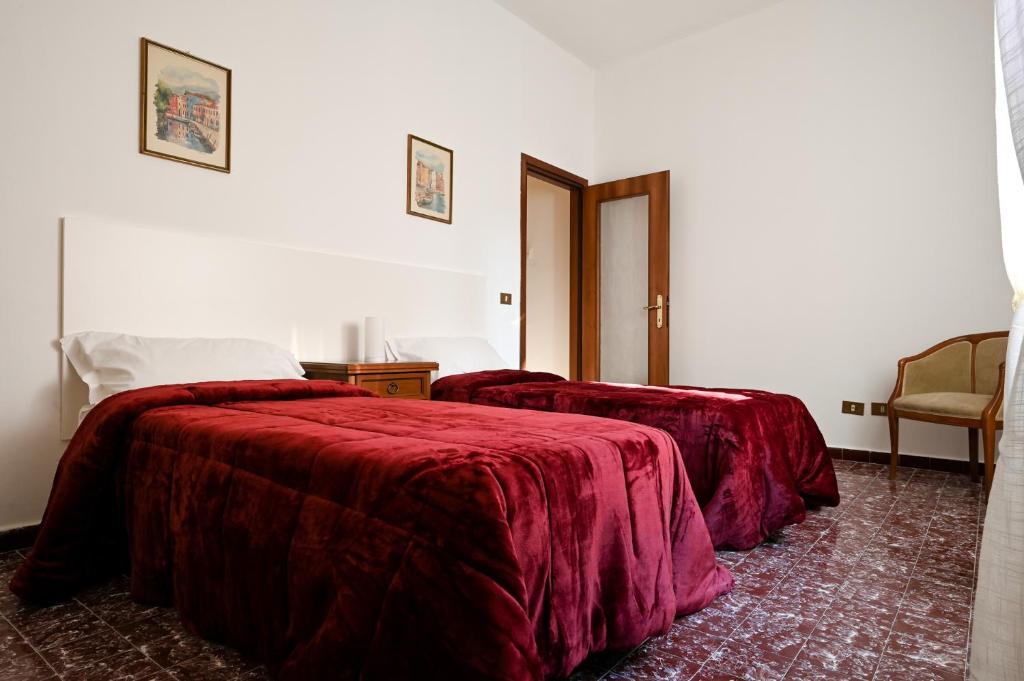 1 Schlafzimmer mit 2 Betten und roten Decken in der Unterkunft Venice Green Lagoon - 20 min da Venezia in Mestre