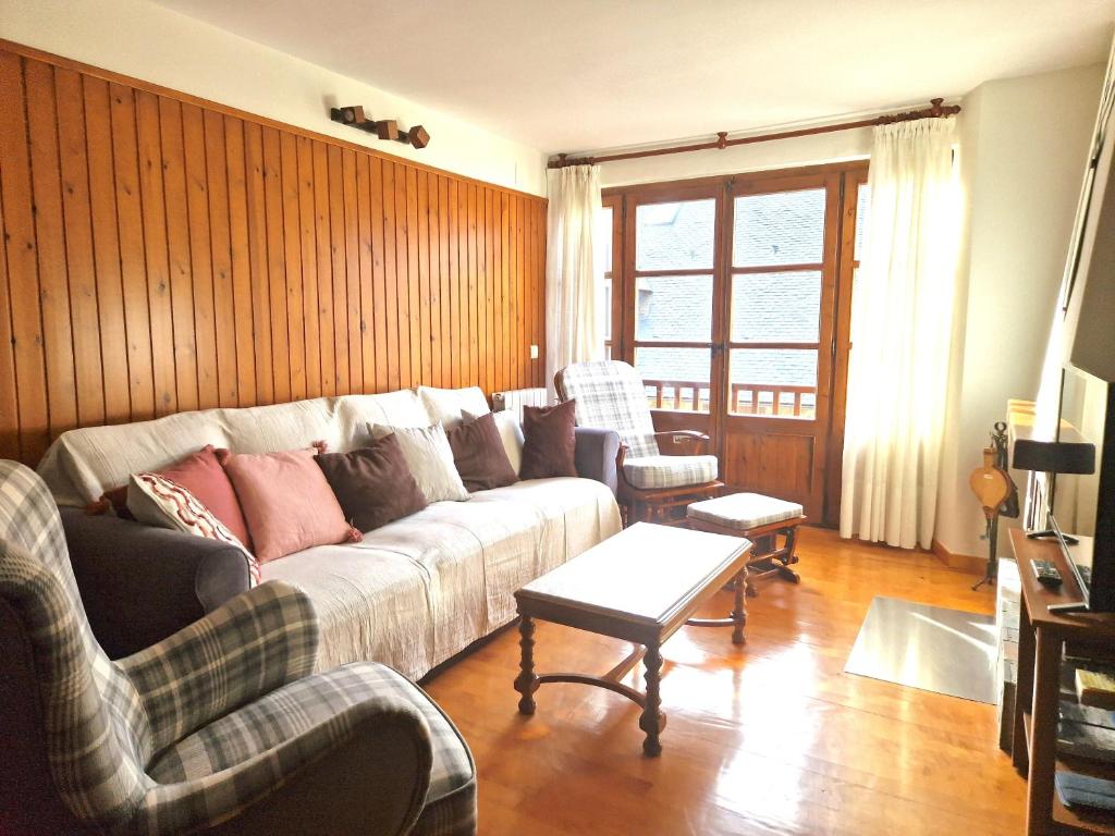 a living room with a couch and two chairs at Dúplex familiar i amb vistes al centre d’Esterri by RURAL D'ÀNEU in Esterri d'Àneu