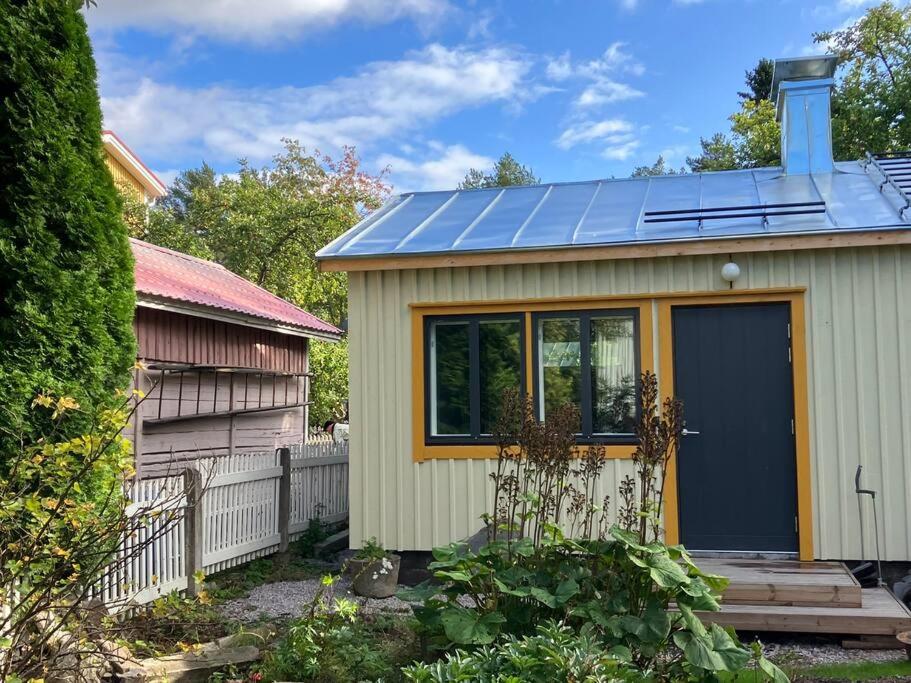 una pequeña casa con paneles solares encima en Garden house near centre, en Tampere