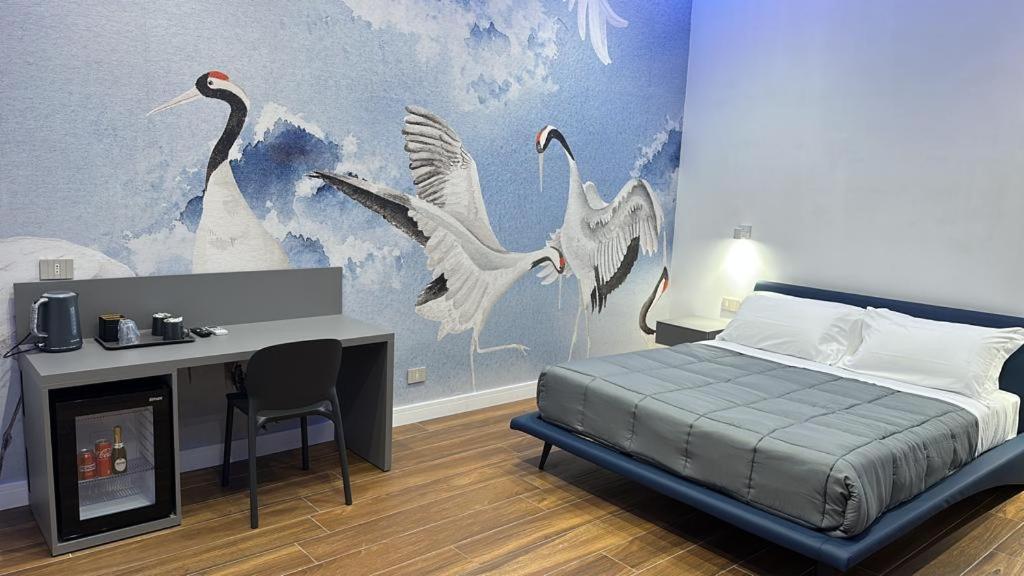 a bedroom with a bed and a desk and birds at palazzo chinial in Torre del Greco