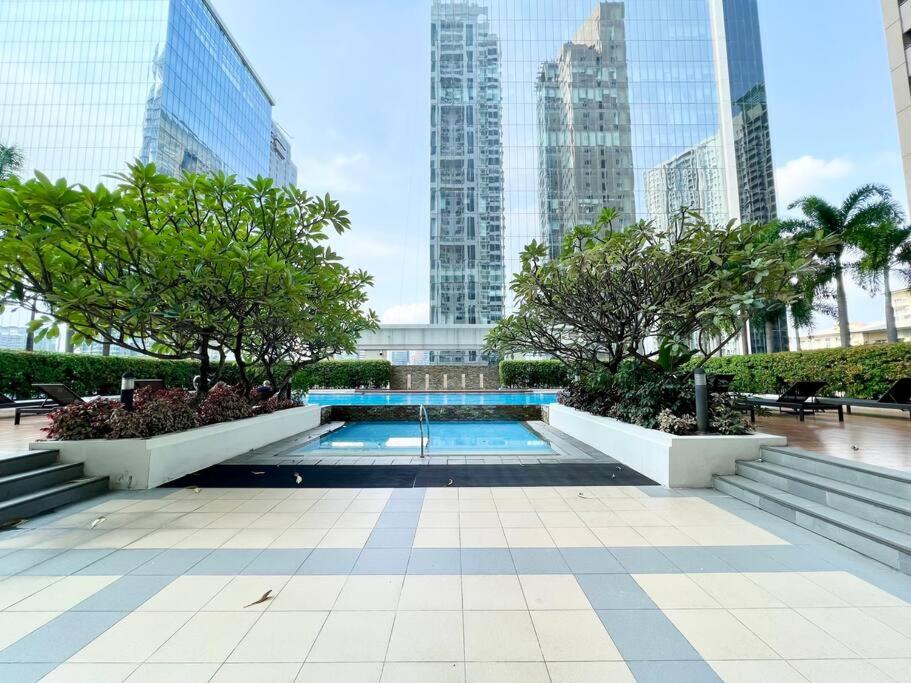a swimming pool in a city with tall buildings at Two Bedroom Condo in BGC with Balcony, Sauna, & Pool in Manila