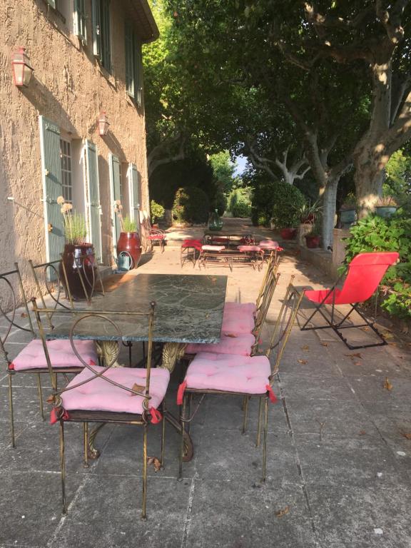 grupa krzeseł i stół z różowymi siedzeniami w obiekcie Campagne Valmont w Aix-en-Provence