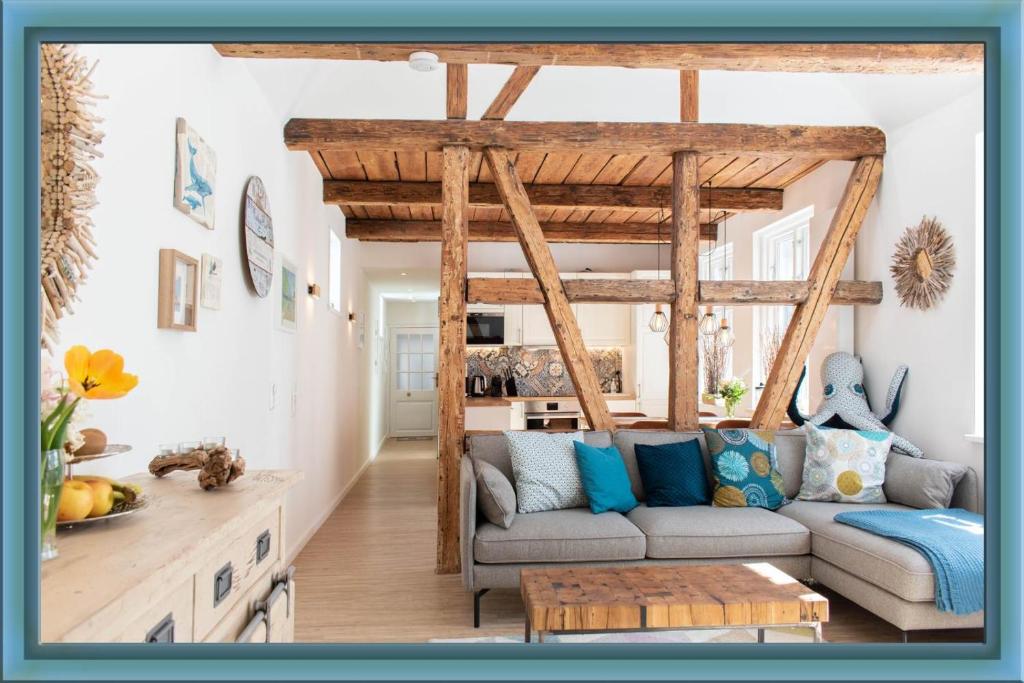 ein Wohnzimmer mit einem Sofa und einem Tisch in der Unterkunft Ferienwohnung Nordic Nature Loft in Travemünde direkt in der Vorderreihe inkl Privatsauna in Travemünde