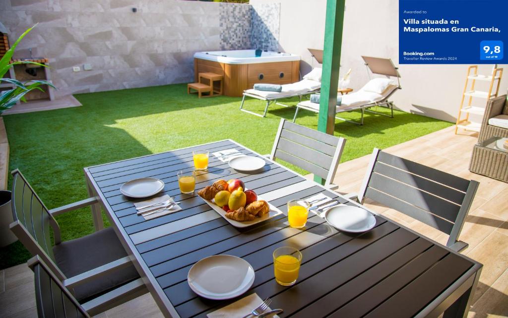 a blue table with a bowl of fruit on it at Villa situada en Maspalomas Gran Canaria, in Maspalomas