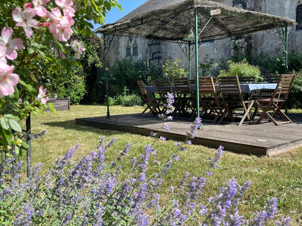 une terrasse en bois avec une table et des chaises dans un jardin dans l'établissement MAISON L, à Tour-en-Sologne