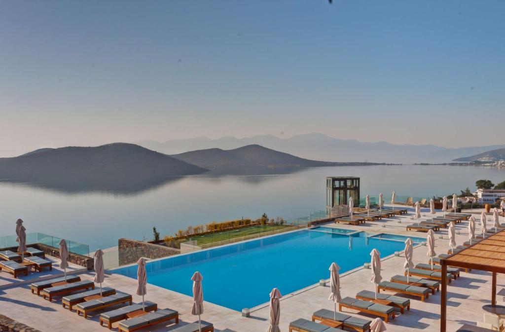 uma vista para o lago a partir de uma piscina do hotel em Royal Marmin Bay Boutique & Art Hotel em Elounda