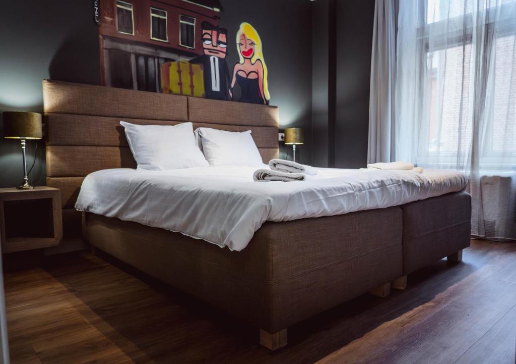 a bedroom with a large bed with a wooden headboard at Tres Boutique Hotel in Gorinchem