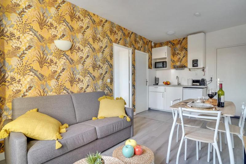 a living room with a couch and a kitchen at 808 Chic Suite - Superb Apartment in Bagnolet