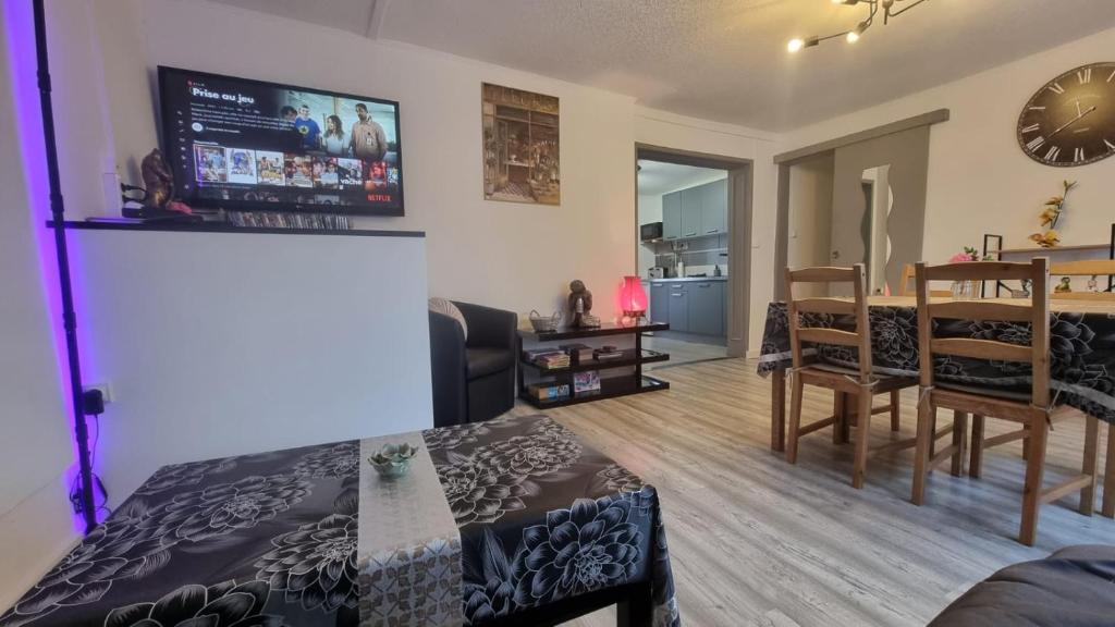 ein Wohnzimmer und ein Esszimmer mit einem TV an der Wand in der Unterkunft Appartement Rethel - Netflix - Marc & cécile in Rethel