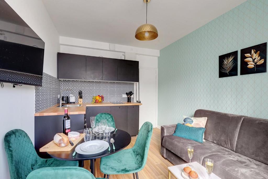 ein Wohnzimmer mit einem Sofa, einem Tisch und Stühlen in der Unterkunft 870 Suite Trefle - Superb apartment in Montreuil