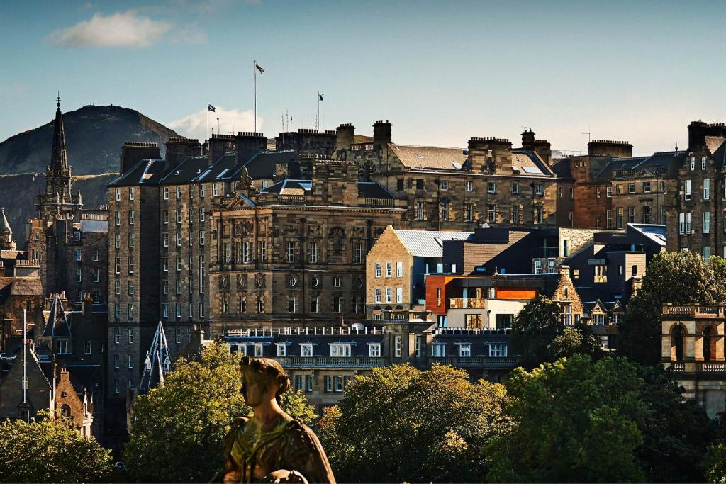 una mujer parada frente a una ciudad con edificios en Apart Bernard Rooms en Edimburgo