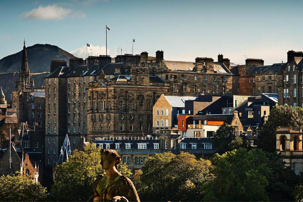 a woman standing in front of a city with buildings at Apart Bernard Rooms in Edinburgh