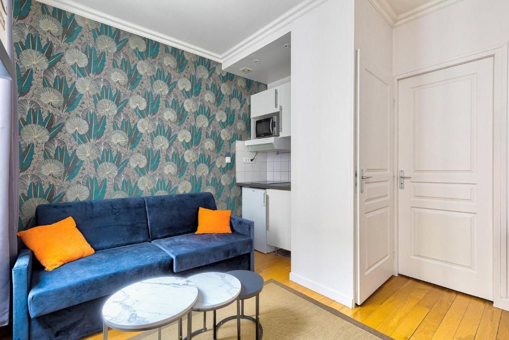 uma sala de estar com um sofá azul e almofadas laranja em 316 Suite BIOT 6 - Superb apartment in Paris em Paris