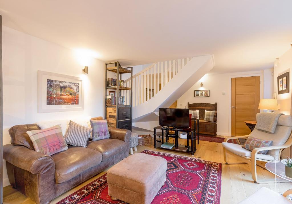a living room with a couch and a tv at The Albany Lane Residence in Edinburgh