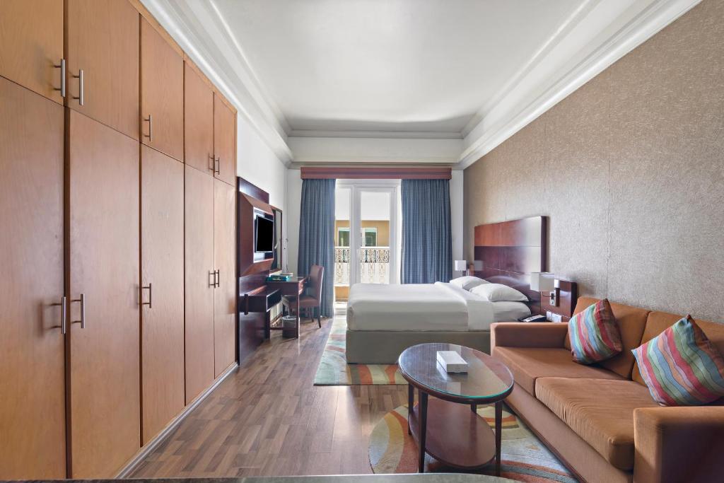ein Hotelzimmer mit einem Bett und einem Sofa in der Unterkunft Al Khoory Hotel Apartments Al Barsha in Dubai
