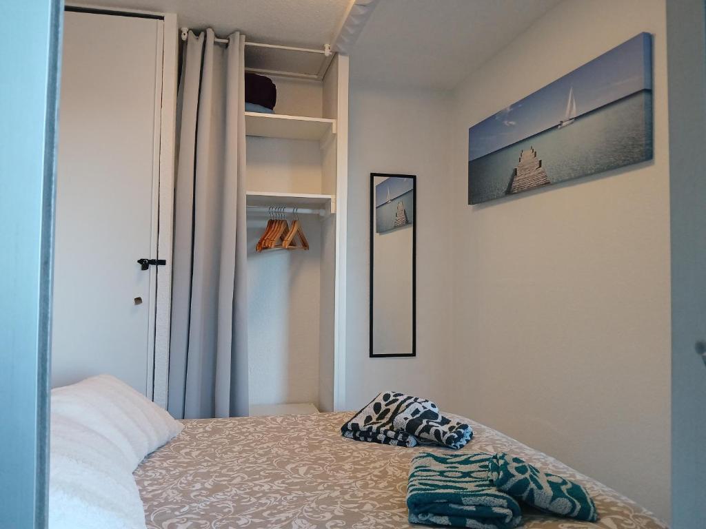 a small bedroom with a bed and a mirror at "LE MILODOINE" Entre Mer et Piscine in Sète