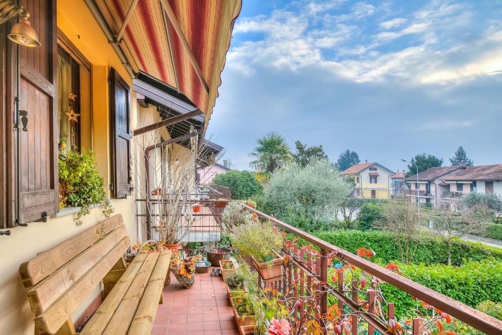 Un balcón con un banco y flores. en Viviana Apartment - Happy Rentals, en  Monvalle 