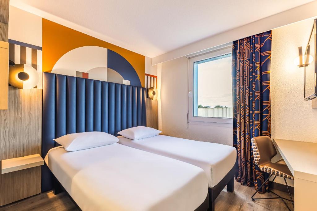 Postel nebo postele na pokoji v ubytování ibis Styles Saint-Quentin
