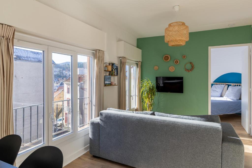 sala de estar con sofá y dormitorio en L' Oriol à Chatel-Guyon en Châtel-Guyon