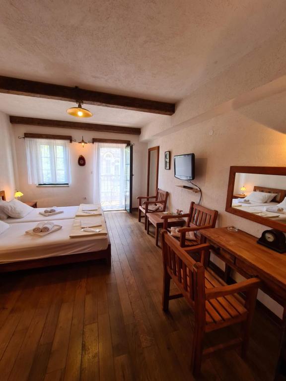 Cette chambre comprend deux lits, une table et des chaises. dans l'établissement Skver Studio Apartments, à Herceg-Novi