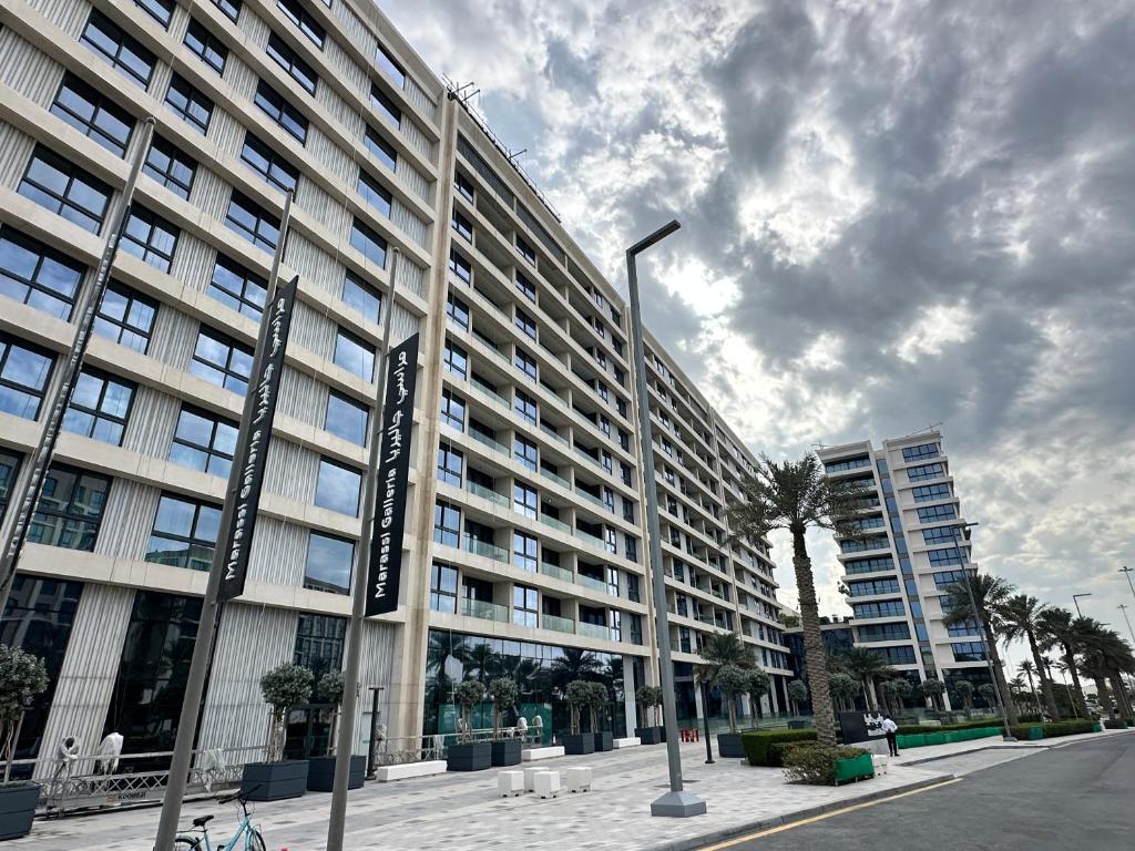 un gran edificio con una luz de la calle delante de él en Marassi Beach Residence en Rayyā