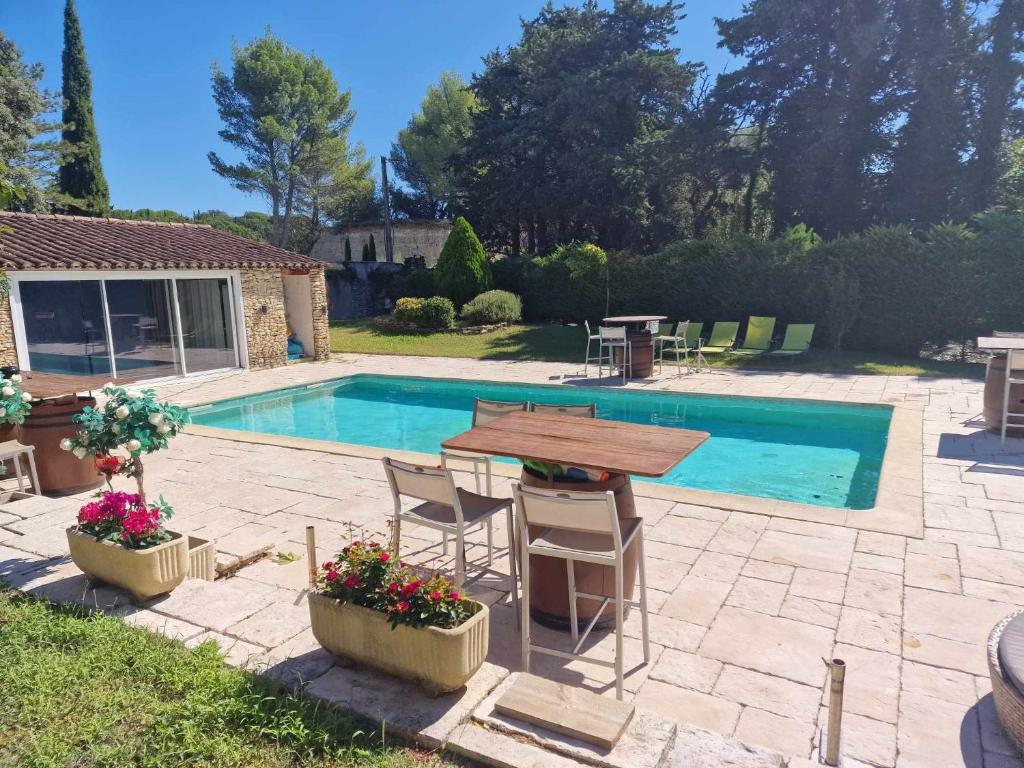 un patio con mesa y sillas junto a una piscina en Maison proche Dentelles Ventoux et Avignon, en Sarrians