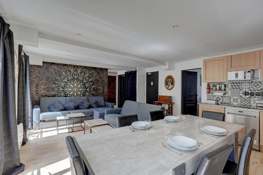 Il comprend une cuisine et un salon avec une table et un canapé. dans l'établissement 303 Suite Simha - Superbe Appartement à Paris, à Paris