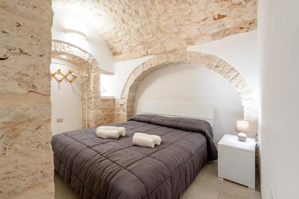 a bedroom with a large bed in a stone wall at Casa Vita 49 in Ceglie Messapica